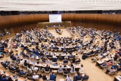 Edustajat istumassa suuressa kokoussaliassa ILO:n kansainvälisen työkonferenssin (ILC) 2025 istunnon aikana