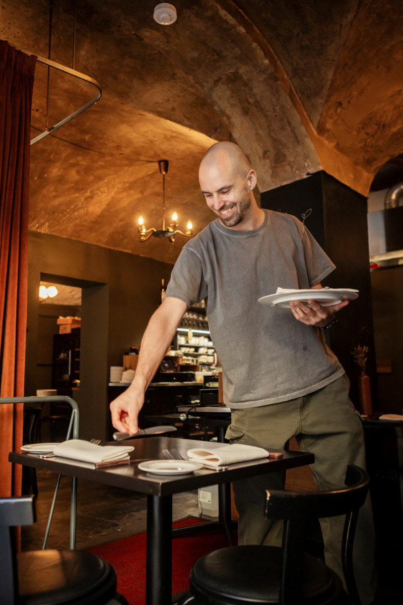 Tarjoilija Leif Halverson asettelee aterimia ravintolan pöytään