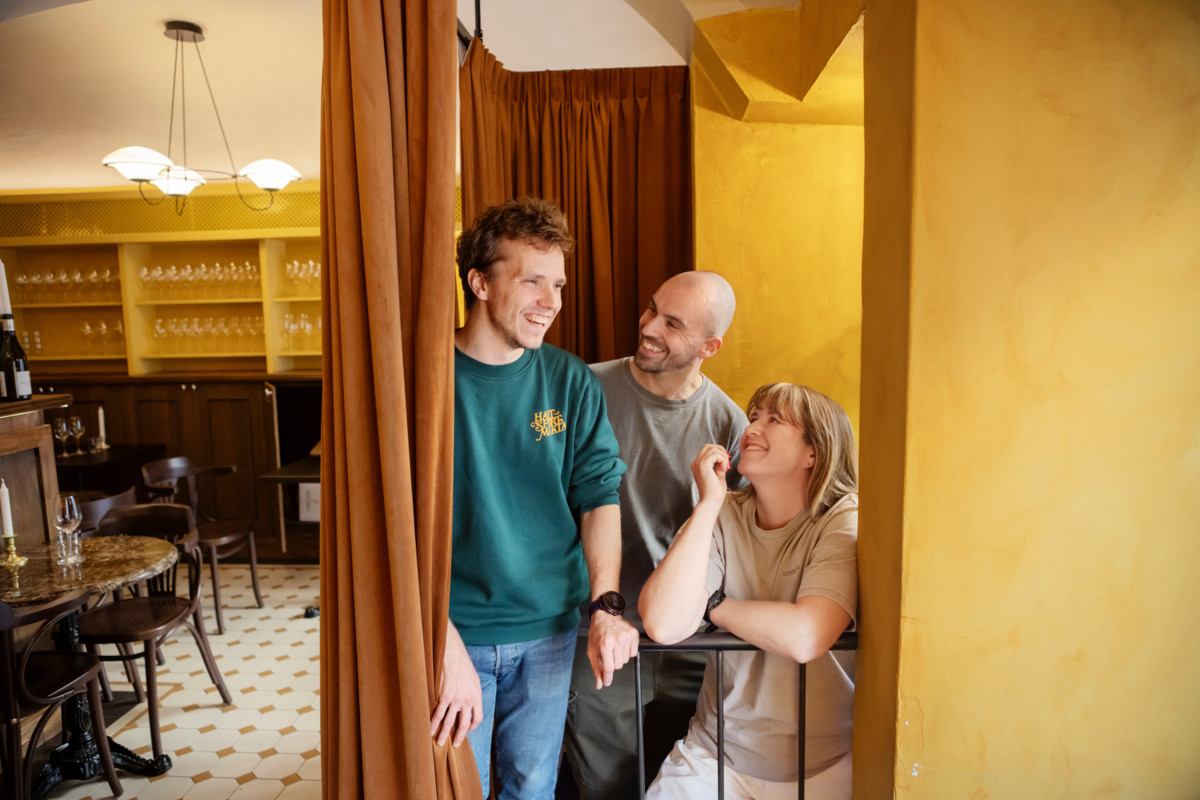 Kuvassa vasemmalla ravintoloitsija Tom Hansen, keskellä tarjoilja Leif Halverson ja oikealla ravintoloitsija Laura Styyra. Henkilöt katsovat toisiaan hymyillen.