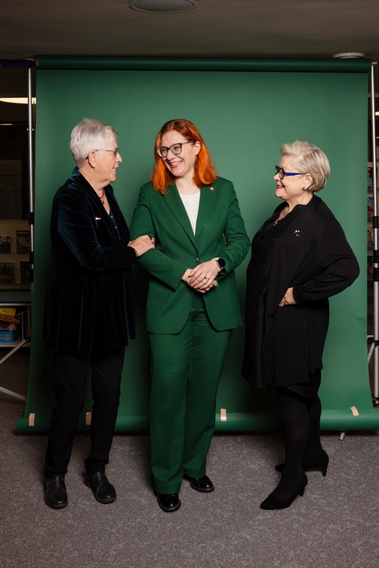 PAMin historian puheenjohtajat Maj-Len Remahl, Annika Rönni-Sällinen ja Ann Selin yhteiskuvassa seisovat vihreän taustakankaan edessä.