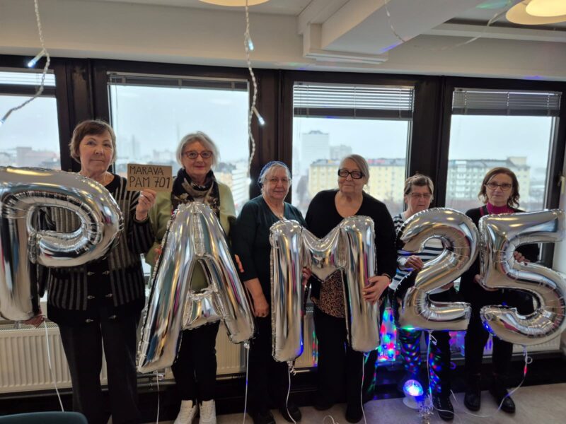 Ilmapalloissa kirjaimet PAM 25 ja ihmisiä niiden takana