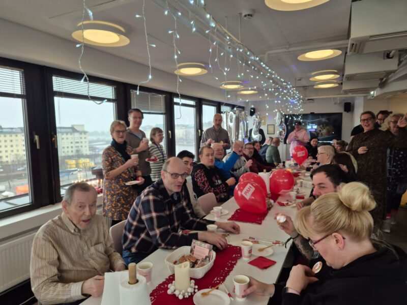 Ihmisiä kakkukahveilla PAMin toimistolla