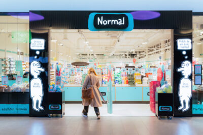 Nuori nainen astelee sisään Normal -ketjun myymälään.