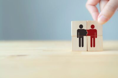 Kuvassa kaksi puista palikkaa, joissa on henkilöitä kuvaavat eriväriset ikonit.