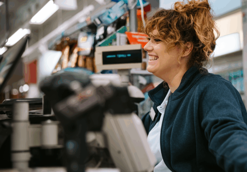 Ystävällinen kassatyöntekijä ruokakaupan kassalla.