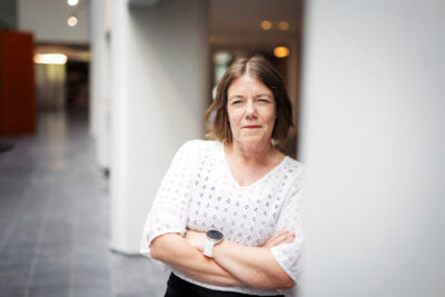 PAMin työehtojohtaja Sirpa Leppäkangas seisoo kädet puuskassa ja katsoo kameraan