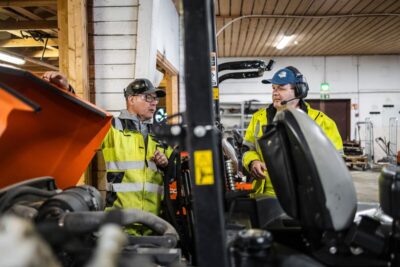 Vesa Heikkinen ja Jukka Riikonen keskustelevat golfkärryn vieressä.