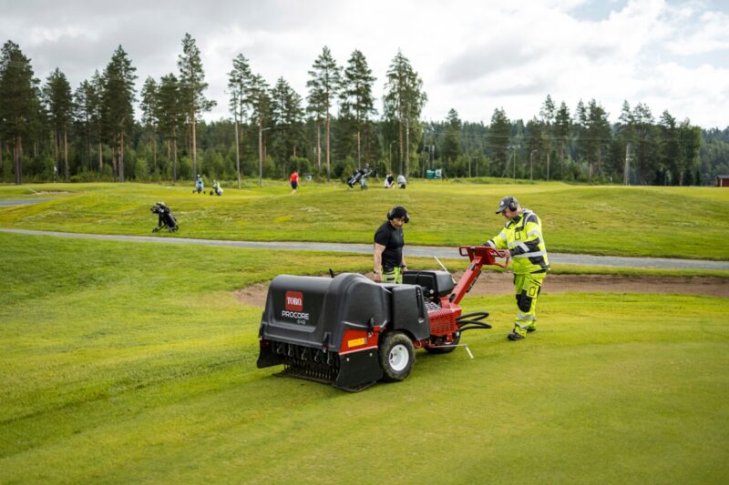 Golfkentän hoitaja ajaa nurmen ilmastuskonetta Tarina Golfilla Siilinjärvellä.